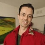 An Indigenous man in a red sweatshirt.