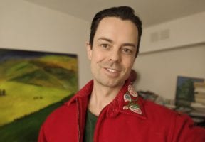 An Indigenous man in a red sweatshirt.