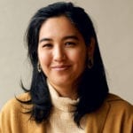 An Asiam woman in a light beige turtleneck.