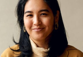 An Asiam woman in a light beige turtleneck.