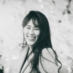 A black and white photo of an Asian woman with long dark hair.