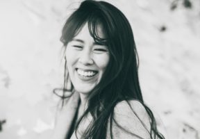 A black and white photo of an Asian woman with long dark hair.