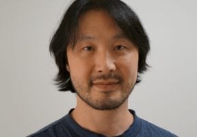 An asian man wearing a dark blue shirt