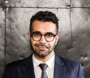 Photo of author Omar Mouallem--a young Lebanese-Canadian man with short dark hair, a small beard, and glasses
