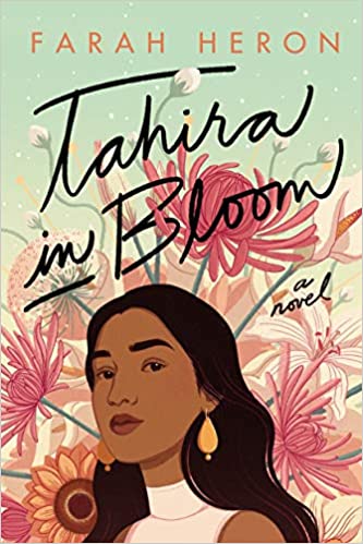 An illustrated book cover showing a young Indian woman with long gold dangly earrings, wearing a short-sleeved turtleneck top against a background of pink flowers. Text: TAHIRA IN BOOM, by Farah Heron.